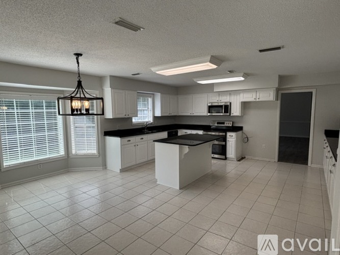 A modern kitchen with white cabinets and a large island.
