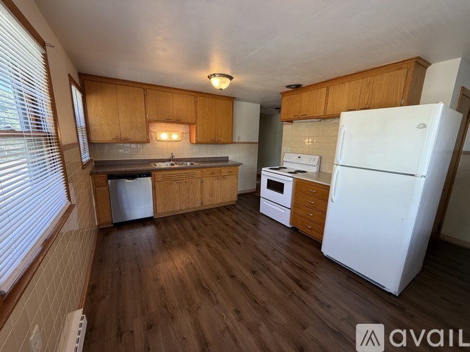 A kitchen with wooden cabinets and a white refrigerator.
