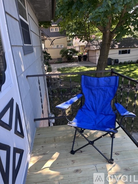 A blue folding chair is on a wooden deck.