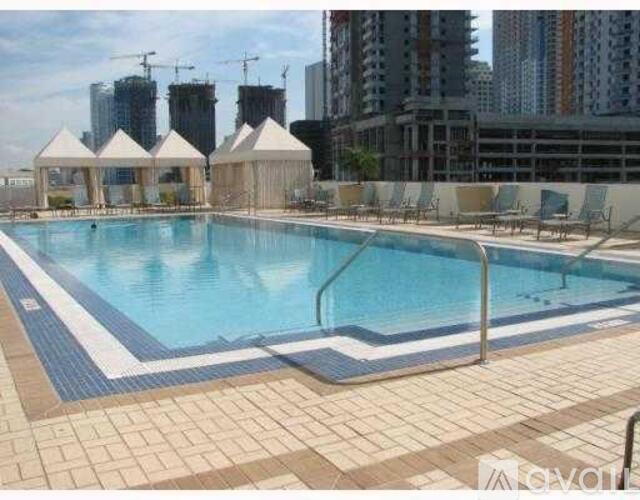 A large outdoor swimming pool with a tiled edge and a metal railing.