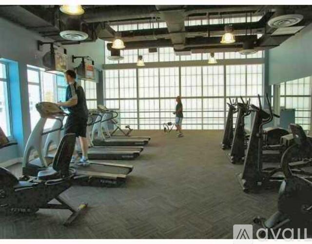 A gym with people exercising and various equipment.