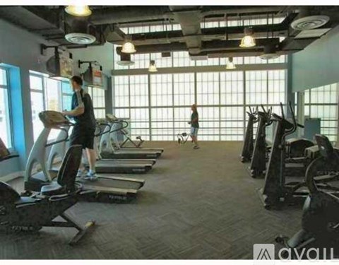 A gym with people exercising and various equipment.