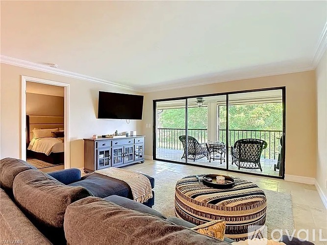 A living room with a large couch and a television mounted on the wall.