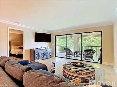 A living room with a large couch and a television mounted on the wall.
