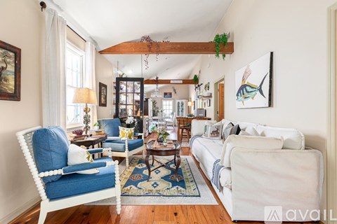 A living room with a white couch and a blue chair.