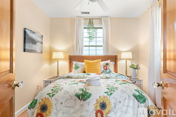 A bedroom with a large bed and a ceiling fan.