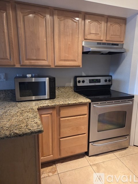 A kitchen with wooden cabinets and a granite countertop.