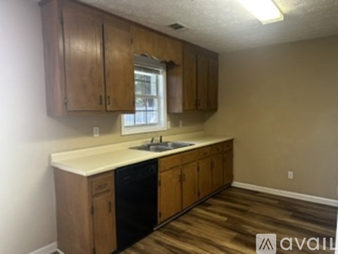 A kitchen with wooden cabinets and a black dishwasher.