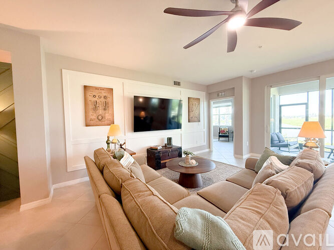 A living room with a long couch and a ceiling fan.