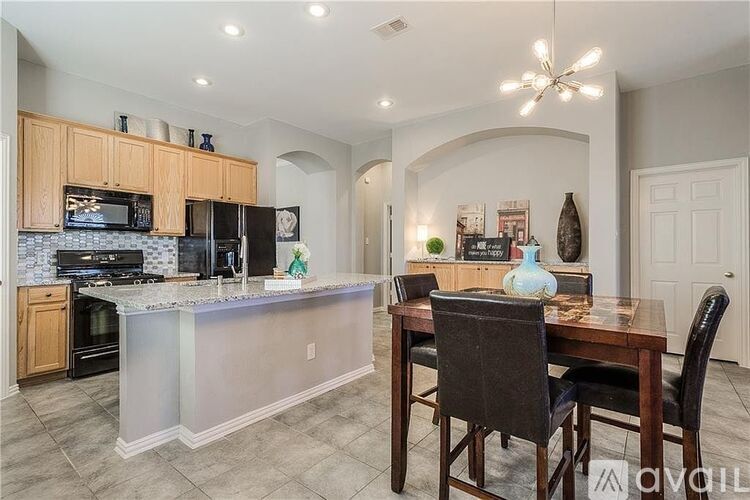 A kitchen with a table and chairs in the middle of the room.