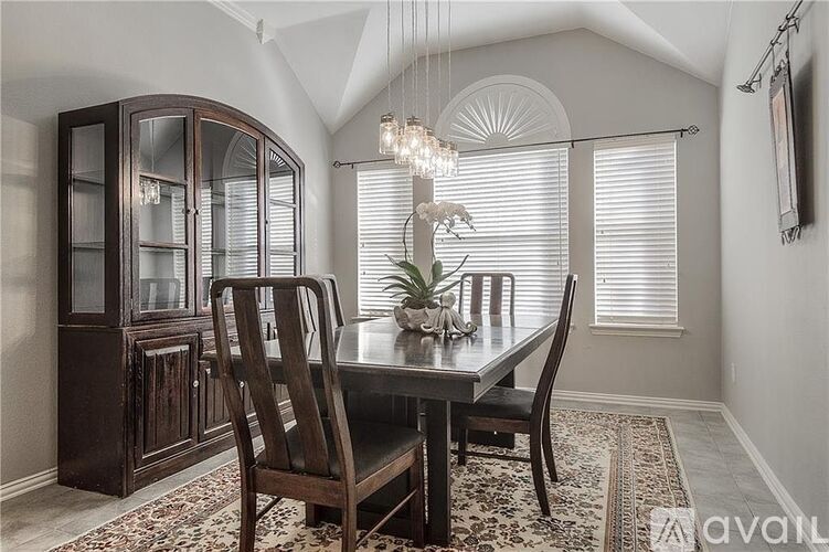 A dining room with a wooden table and chairs.