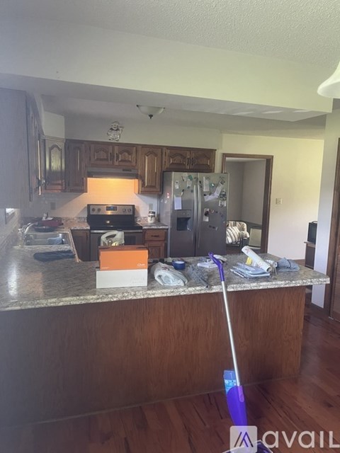 A kitchen with a brown counter top and a purple mop.