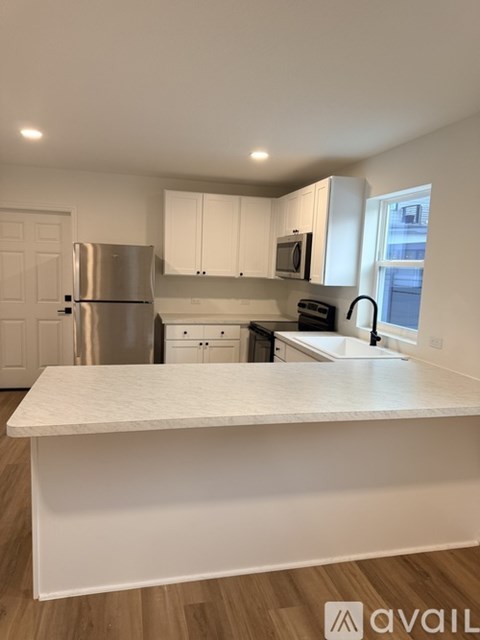 A kitchen with white cabinets and a white countertop.