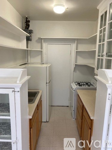 A kitchen with white appliances and wooden cabinets.