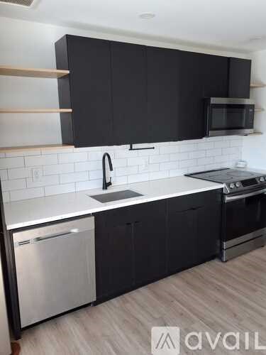 A kitchen with black cabinets and a white countertop.