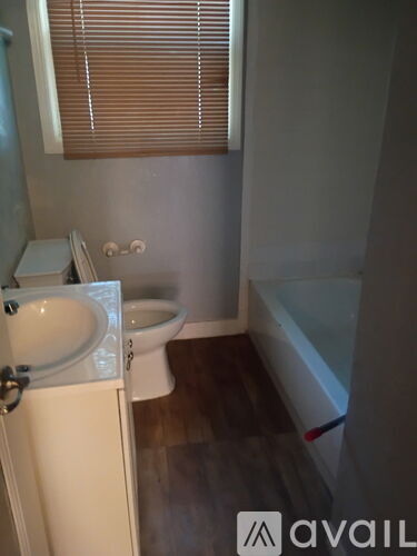 A bathroom with a toilet, sink and bathtub.