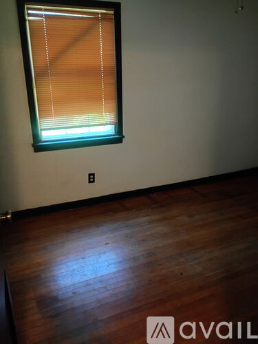 A room with a window and wooden floor.