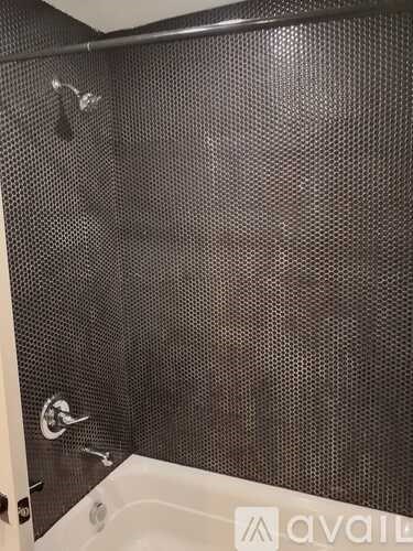 A bathroom with a shower curtain and a white tub.