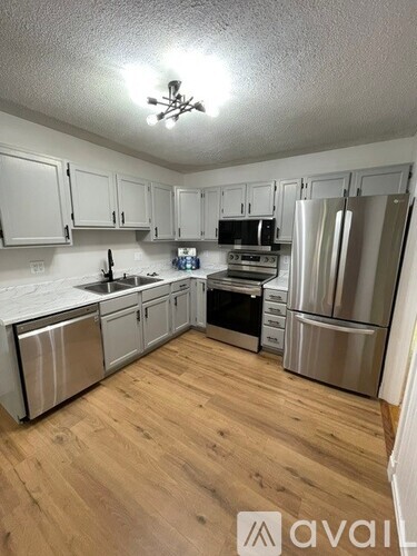 A kitchen with wooden floors and stainless steel appliances.