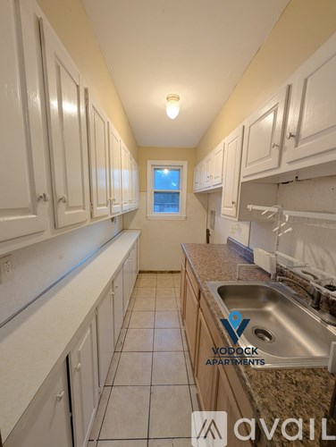 A kitchen with white cabinets and a granite counter top.