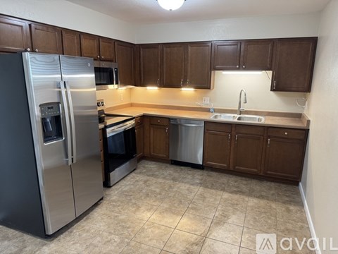 A kitchen with brown cabinets and a stainless steel refrigerator.