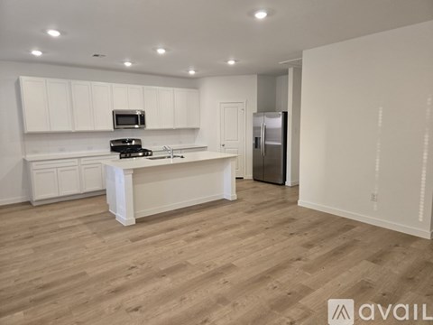 A kitchen with white cabinets and a wooden floor.