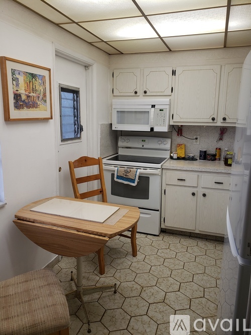 A kitchen with a table and a fridge.