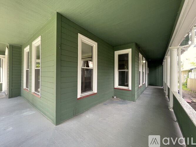 A long green building with windows and doors.