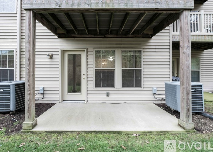 A house with a covered entrance has a window and a door.