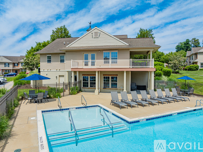 A house with a pool and lounge chairs.