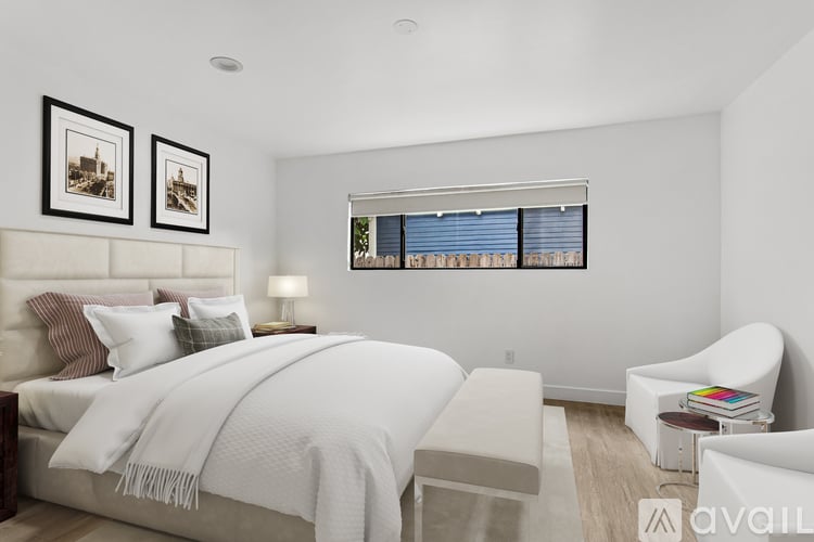 A bedroom with a large bed and a chair.