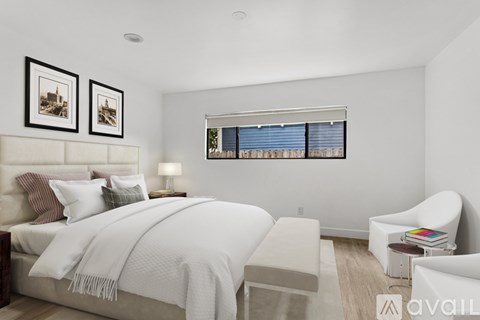 A bedroom with a large bed and a chair.