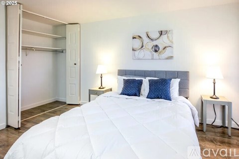 A bedroom with a large bed and a painting on the wall.