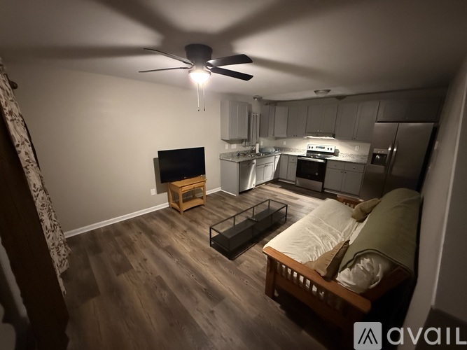 A bedroom with a bed, a table, and a television.