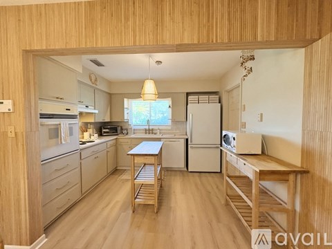 A kitchen with wooden cabinets and a refrigerator.