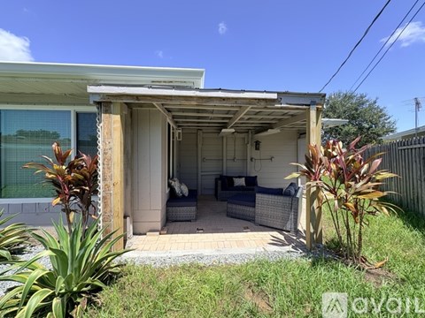 A house with a patio and a covered entrance.