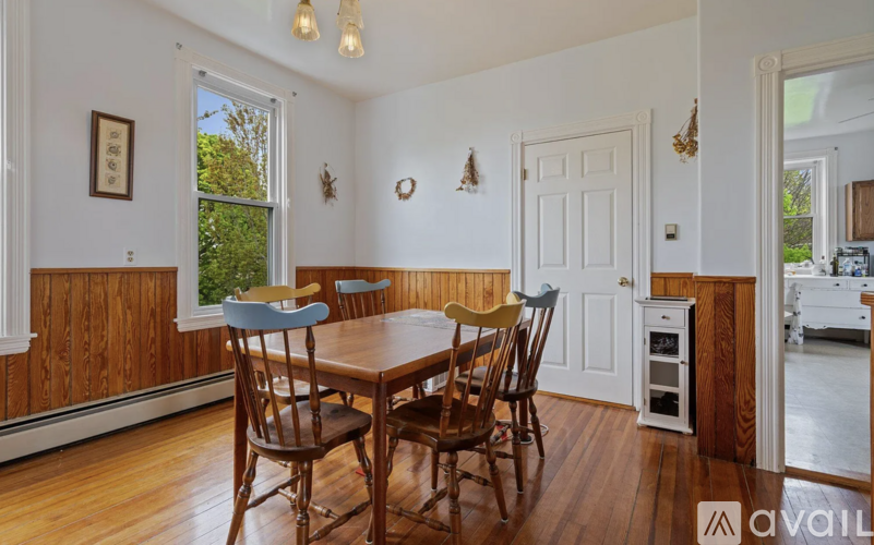 A dining room with a wooden table and chairs.