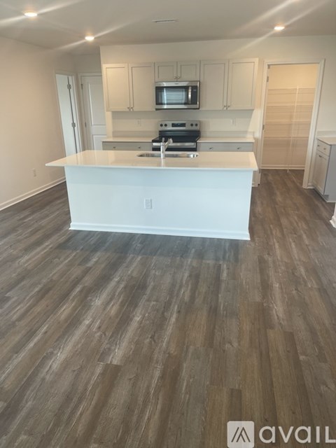 A kitchen with a white island and wooden floors.