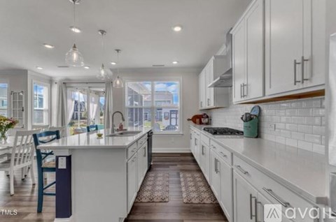 A modern kitchen with white cabinets and a large island.