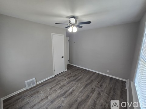 A room with a ceiling fan and a door.