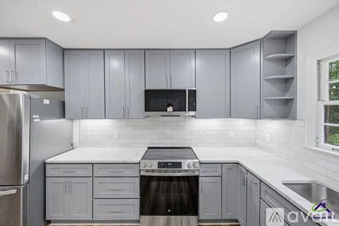 A modern kitchen with a stainless steel refrigerator and a black oven.