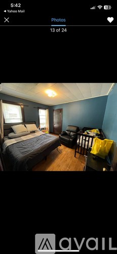 A bedroom with a bed, chair, and window.