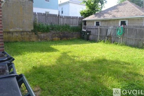 A backyard with a wooden fence and a small shed.