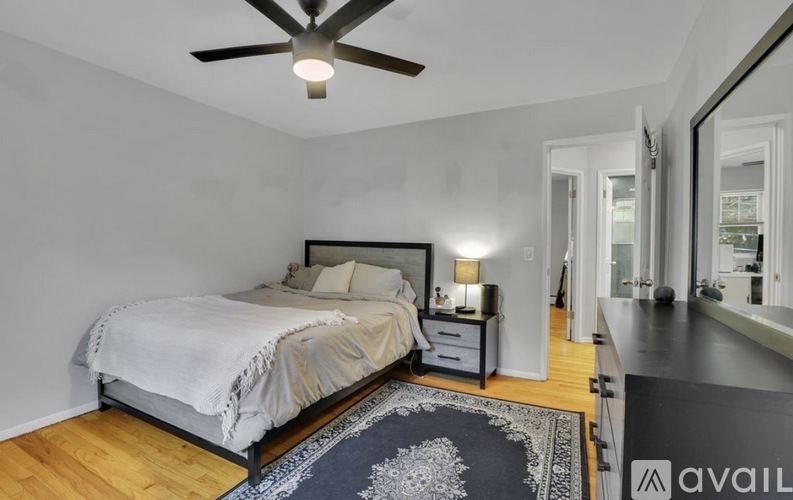 A bedroom with a bed, nightstand, and a ceiling fan.