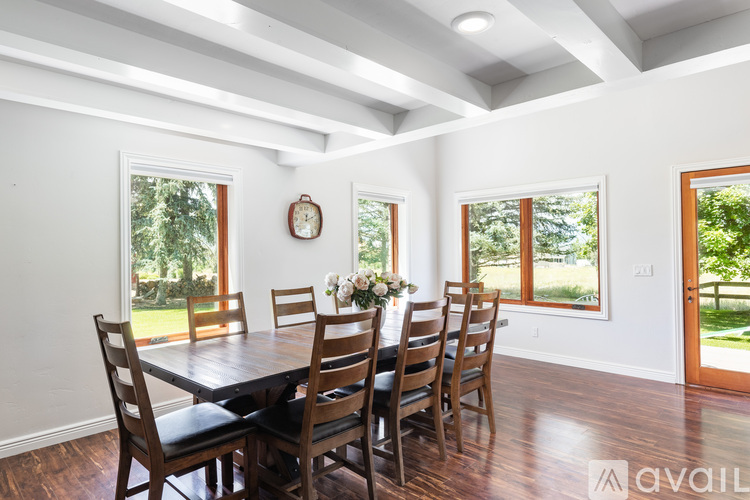 A dining room with a wooden table and chairs.