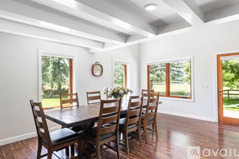 A dining room with a wooden table and chairs.