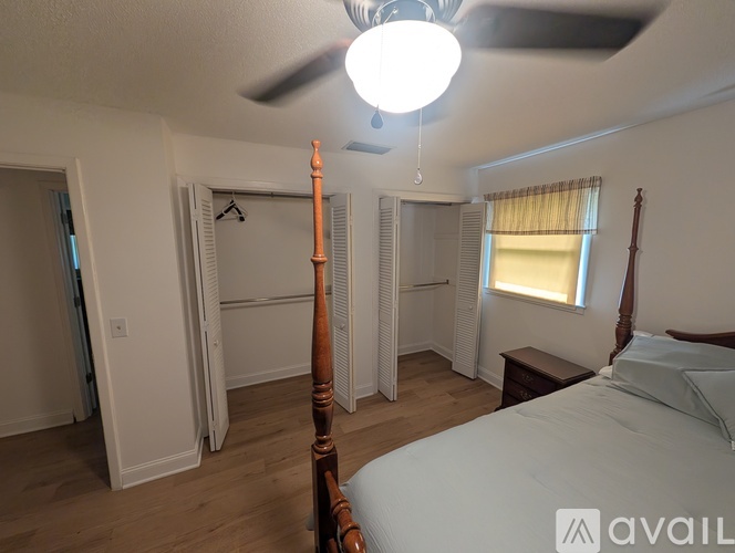 A bedroom with a bed, dresser, and window with blinds.