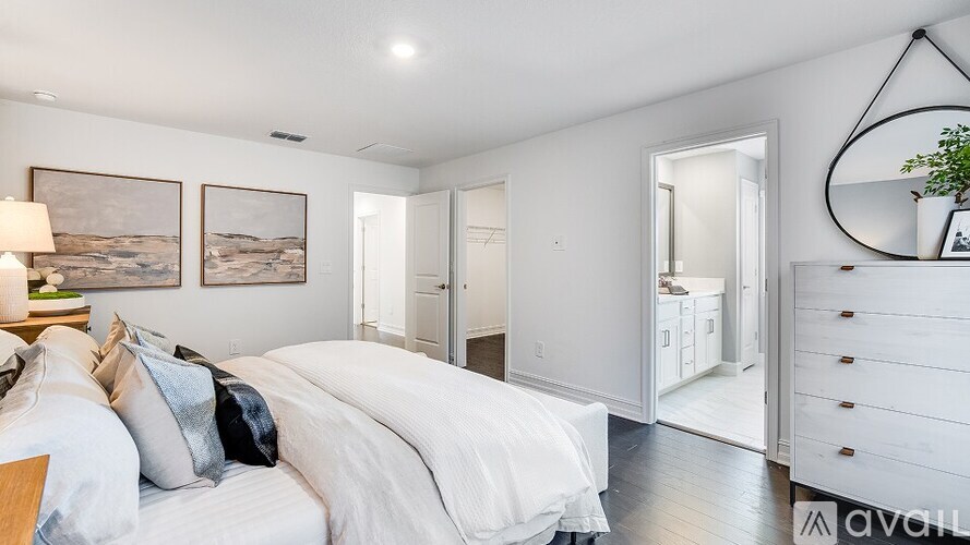 A bedroom with a large bed and a painting on the wall.