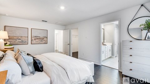 A bedroom with a large bed and a painting on the wall.