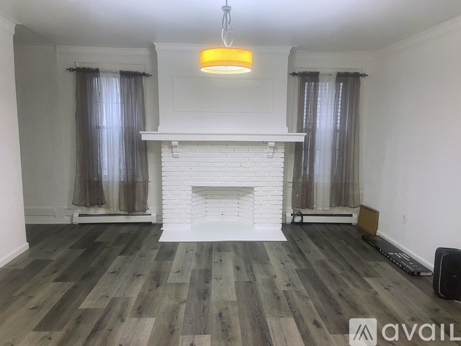 A living room with a fireplace and wooden flooring.